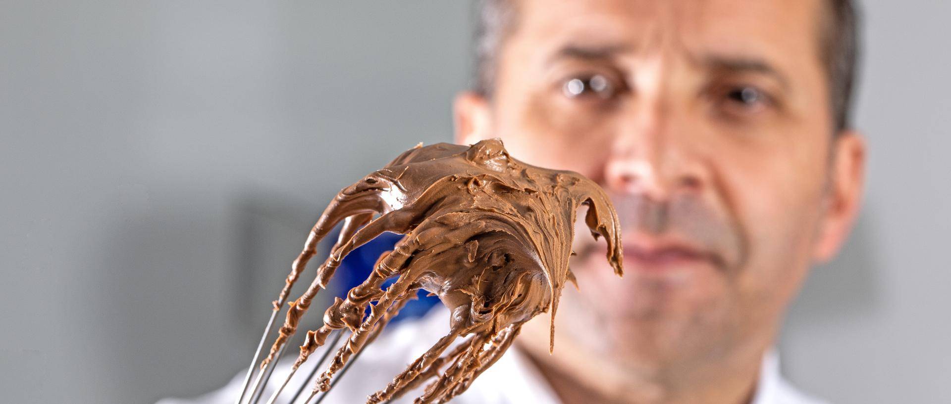chef bertrand segurando um fouet com chocolate na ponta