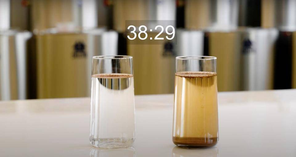 Two glasses of water side by side with cacao powder dissolving in them