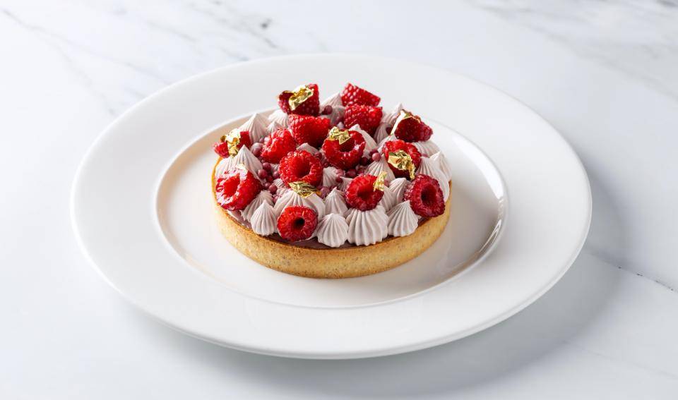 A tart wth ruby whipped ganache and raspberries