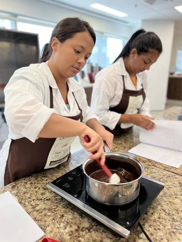 pessoas trabalhando com chocolate em cima do balcão