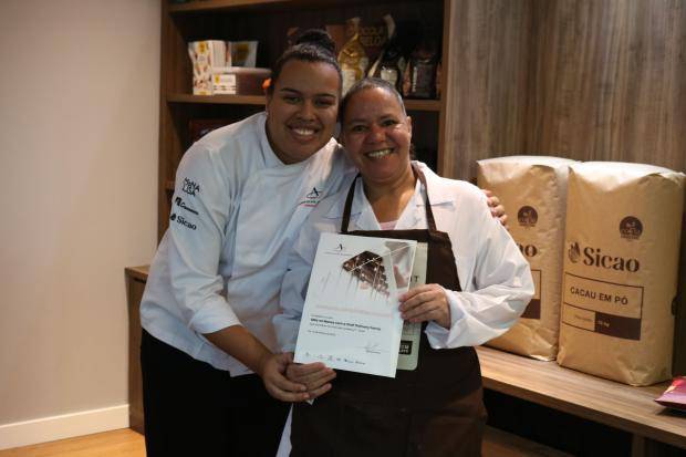 Chef entregando certificado de conclusão de curso para aluna