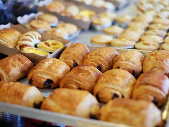 "Witryna cukiernicza z croissantami i innymi wypiekami"